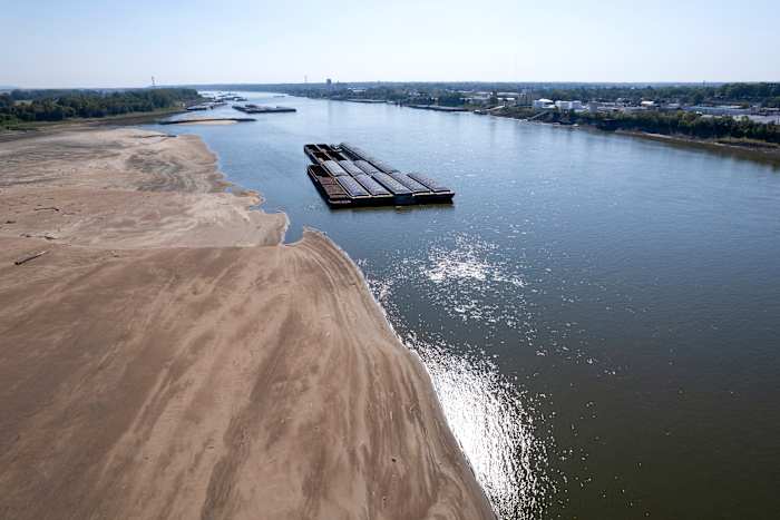 BESTAND - Binnenvaartschepen drijven in de rivier de Mississippi terwijl een deel van de rivierbedding op 15 september 2023 in St. Louis bloot komt te liggen. Het VN-weeragentschap meldt dat 2023 voor de rivieren in de wereld het droogste jaar in meer dan drie decennia was, omdat het recordwarme jaar aan de basis lag van het opdrogen van de waterstromen en op sommige plaatsen bijdroeg aan langdurige droogtes. (AP Foto/Jeff Roberson, Bestand)