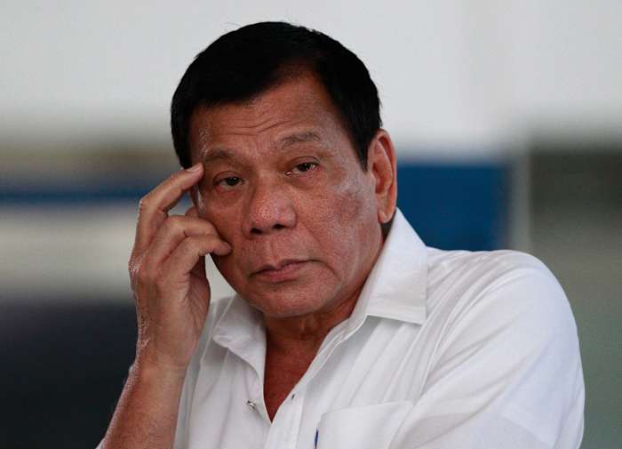 BESTAND - De Filippijnse president Rodrigo Duterte luistert naar een vraag van verslaggevers op de internationale luchthaven van Manila, Filipijnen, op 9 november 2016. (AP Photo/Aaron Favila, File)
