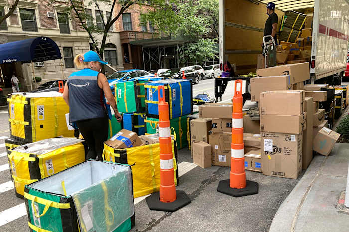 BESTAND - Een Amazon-werknemer sorteert leveringen op een straathoek aan de Upper West Side in New York, 14 augustus 2023. (AP Photo/Richard Drew, File)