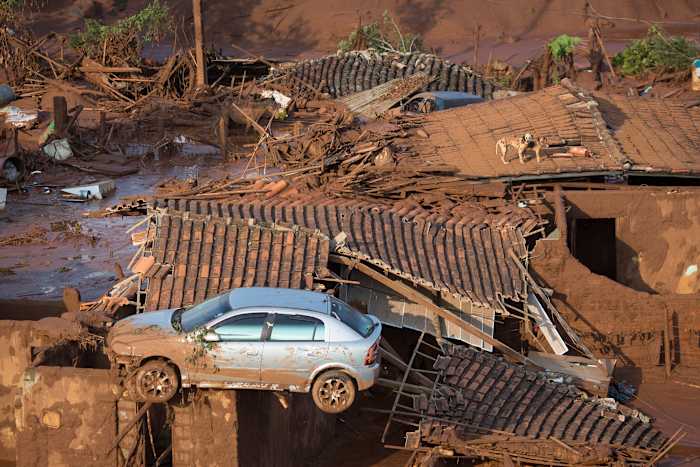 BESTAND - Een auto en twee honden staan ​​op het dak van verwoeste huizen in het kleine stadje Bento Rodrigues nadat een dam barstte in de staat Minas Gerais, Brazilië, 6 november 2015. (AP Photo/Felipe Dana, File)