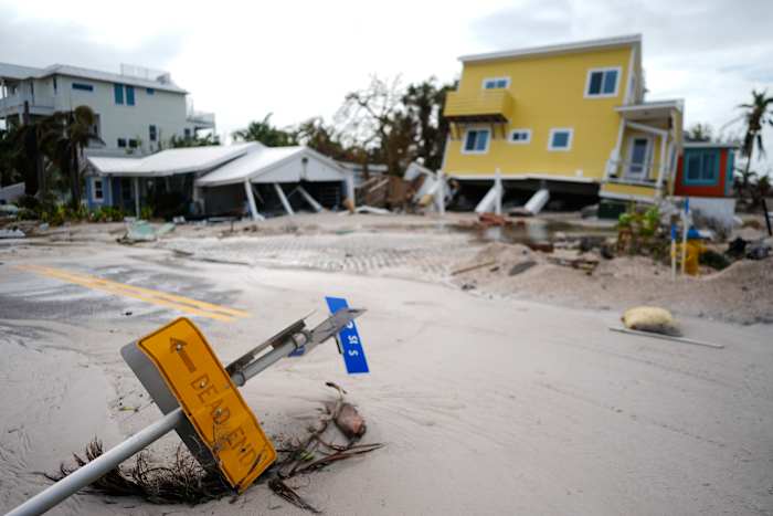 BESTAND - Een huis is van zijn palen gevallen na de passage van de orkaan Milton, naast een leeg perceel waar een huis werd weggevaagd door de orkaan Helene, in Bradenton Beach op Anna Maria Island, Florida, 10 oktober 2024. (AP Photo /Rebecca Blackwell, bestand)