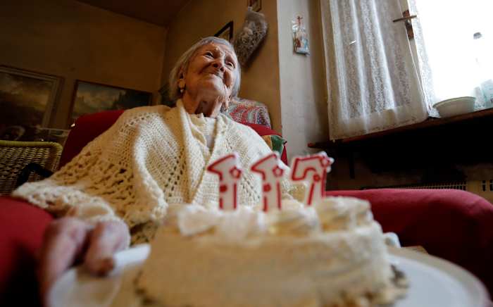 BESTAND- Emma Morano houdt een taart met kaarsen vast ter gelegenheid van 117 jaar op de dag van haar verjaardag, 29 november 2016, in Verbania, Italië. (AP Foto/Antonio Calanni)