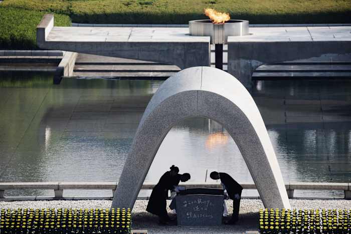 BESTAND - Kazumi Matsui, rechts, burgemeester van Hiroshima maakt een buiging bij de Hiroshima Memorial Cenotaph, in het Hiroshima Peace Memorial Park in Hiroshima, West-Japan, 6 augustus 2015. De Nobelprijs voor de Vrede is toegekend aan Nihon Hidankyo, een Japanse organisatie van overlevenden van de Amerikaanse atoombommen op Hiroshima en Nagasaki, vanwege zijn activisme tegen kernwapens. (AP Foto/Eugene Hoshiko, bestand)