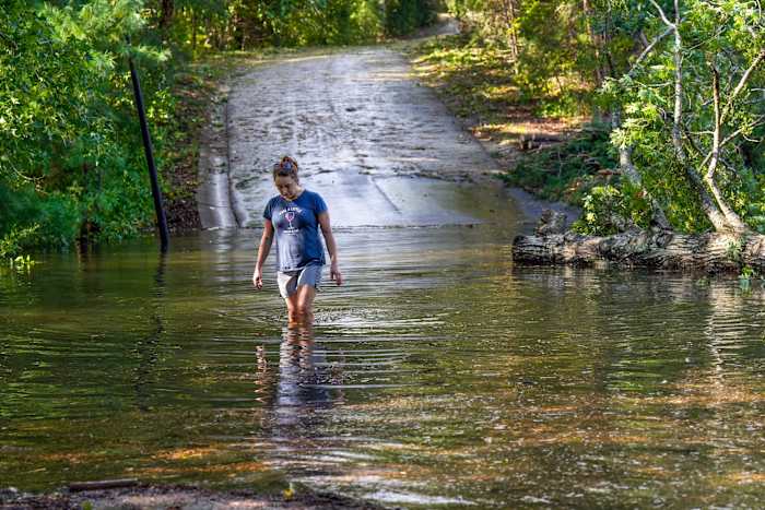 BESTAND - Teresa Elder loopt door een overstroomde Sandy Cove Drive na orkaan Helene, 27 september 2024, in Morganton, NC (AP Photo/Kathy Kmonicek, File)
