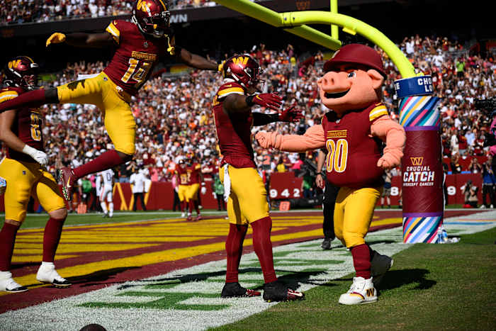BESTAND - Washington Commanders running back Brian Robinson Jr., tweede van rechts, viert zijn touchdown met mascotte Major Tuddy, rechts, tijdens de eerste helft van een NFL-voetbalwedstrijd tegen de Cleveland Browns, zondag 6 oktober 2024, in Landover, Md. Ook te zien is Commanders brede ontvanger Olamide Zaccheaus (14). (AP Foto/Nick Wass, Bestand)