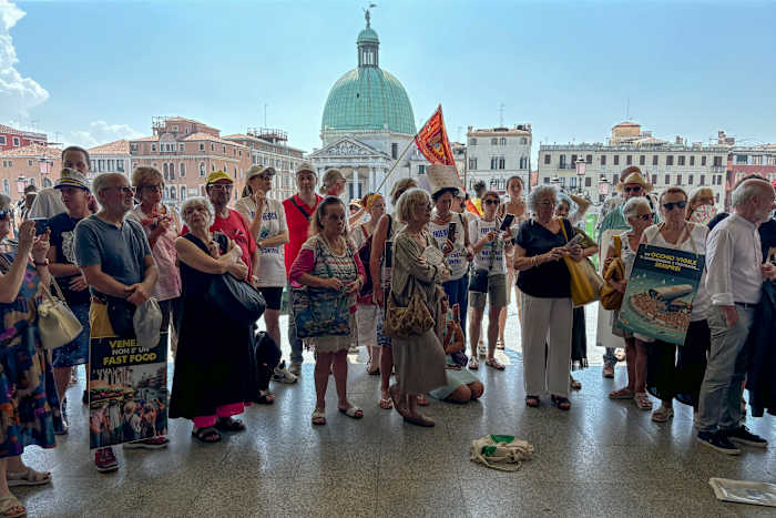 BESTAND – Activisten verzamelen zich op 13 juli 2024 buiten het treinstation Santa Lucia in Venetië om te protesteren tegen een toeslag voor dagjesmensen die bezoekers er volgens hen niet van heeft kunnen weerhouden om op piekdagen te arriveren, zoals voorzien. (AP Foto/Colleen Barry, Bestand)