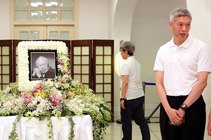 BESTAND – De broer van premier Lee Hsien Loong, Lee Hsien Yang (rechts), ontvangt vrienden en familieleden die hun respect betuigen aan wijlen Lee Kuan Yew tijdens een besloten familiewake in het Istana of presidentieel paleis in Singapore, 24 maart 2015. (AP Foto/Wong Maye-E, bestand)