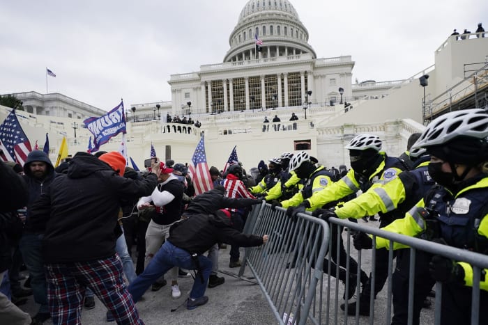 BESTAND – Opstandelingen die loyaal zijn aan president Donald Trump proberen op woensdag 6 januari 2021 een politiebarrière te doorbreken bij het Capitool in Washington. (AP Foto/Julio Cortez, Bestand)