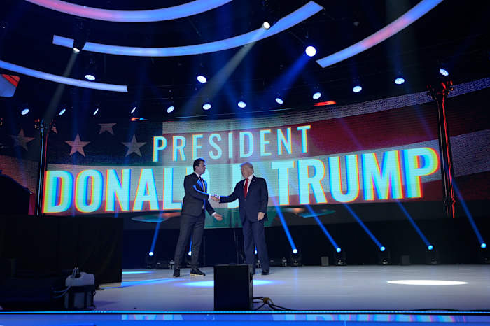 BESTAND – Voormalig president Donald Trump, rechts, schudt Charlie Kirk, CEO van Turning Point, de hand voordat hij spreekt tijdens de Turning Point USA Student Action Summit, zaterdag 23 juli 2022, in Tampa, Florida. (AP Photo/Phelan M. Ebenhack, File )