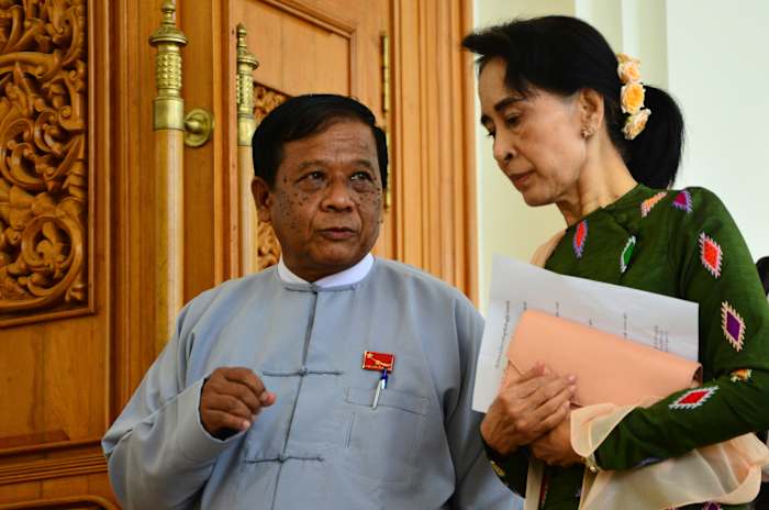 BESTAND – Zaw Myint Maung, links, een gevangengenomen politicus en een naaste collega van de afgezette leider van Myanmar, Aung San Suu Kyi, rechts, praat met Suu Kyi in het parlement in Naypyitaw, Myanmar, op 23 juli 2015. (AP Photo/Aung Shine Oo , Bestand)