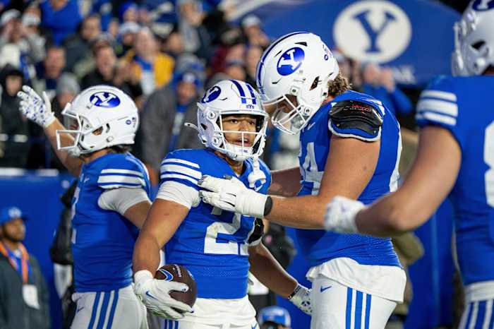 BYU running back LJ Martin, tweede van links, viert feest na het scoren van een touchdown in de tweede helft van een NCAA universiteitsvoetbalwedstrijd tegen Oklahoma State, vrijdag 18 oktober 2024, in Provo, Utah. (AP-foto-/Spenser-hopen)