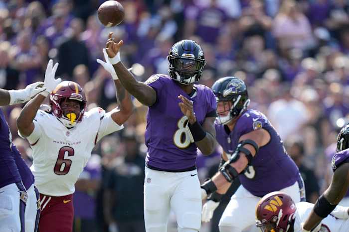 Baltimore Ravens quarterback Lamar Jackson (8) gooit terwijl Washington Commanders linebacker Dante Fowler Jr (6) verdedigt tijdens de eerste helft van een NFL-voetbalwedstrijd tegen de Washington Commanders op zondag 13 oktober 2024 in Baltimore. (AP-foto/Stephanie Scarbrough)