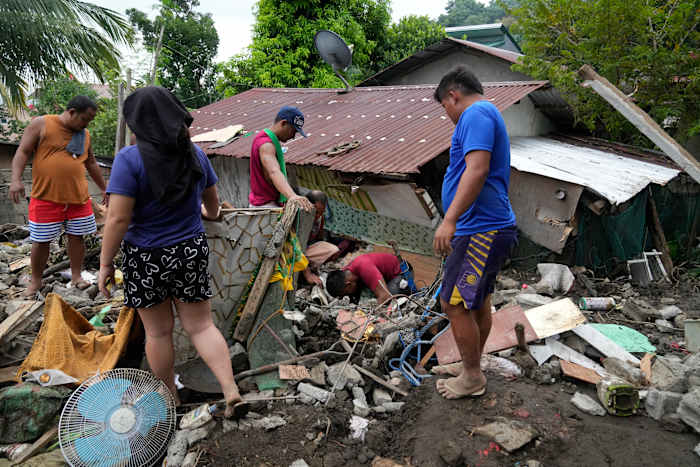 Bewoners proberen persoonlijke bezittingen uit hun beschadigde huis te bergen nadat een aardverschuiving veroorzaakt door de tropische storm Trami onlangs Talisay, provincie Batangas, Filippijnen, zaterdag 26 oktober 2024 trof. (AP Photo/Aaron Favila)
