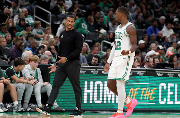 Boston Celtics-hoofdcoach Joe Mazzulla, linksvoor, spreekt met Boston Celtics-bewaker Lonnie Walker IV (12) die naar de teambank loopt tijdens de tweede helft van een NBA-basketbalwedstrijd van het voorseizoen tegen de Toronto Raptors, zondag 13 oktober 2024, in Boston. (AP-foto/Mark Stockwell)