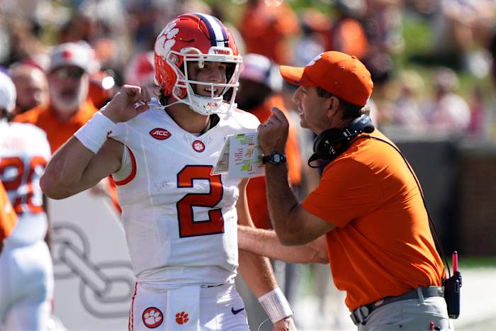 Clemson-hoofdcoach Dabo Swinney, rechts, praat met quarterback Cade Klubnik (2) tijdens de eerste helft van een NCAA-voetbalwedstrijd tegen Wake Forest in Greensboro, NC, zaterdag 12 oktober 2024. (AP Photo/Chuck Burton)