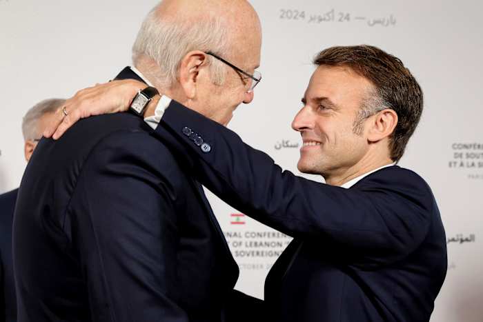 De Franse president Emmanuel Macron omhelst de Libanese premier, premier Najib Mikati, links, tijdens de internationale conferentie voor Libanon in Parijs, donderdag 24 oktober 2024. (Alain Jocard, Pool via AP)