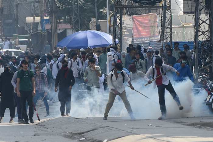 De politie vuurt traangas af om studenten uiteen te drijven die protesteren tegen een vermeende verkrachting op de campus in Punjab, in Rawalpindi, Pakistan, donderdag 17 oktober 2024. (AP Photo/WK Yousafzai).