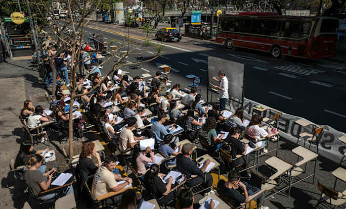 Economiestudenten geven les buiten, voor de Universiteit van Buenos Aires, uit protest tegen het veto van president Javier Milei over een wet om de financiering voor openbare universiteiten te verhogen, in Buenos Aires, Argentinië, 16 oktober 2024. (AP Photo/Victor R. Caivano )