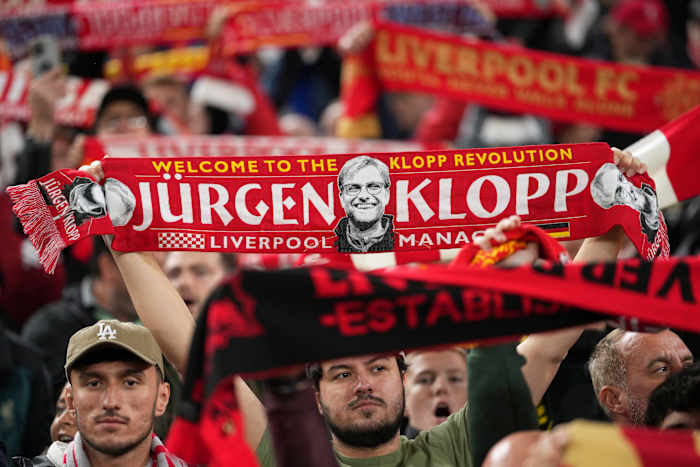 Een Liverpool-fan houdt een sjaal omhoog met een foto van voormalig teamcoach Juergen Klopp, tijdens de Engelse League Cup-voetbalwedstrijd tussen Liverpool en West Ham United in Anfield Stadium, Liverpool, Engeland, woensdag 25 september 2024. (AP Photo/ Jon Super)