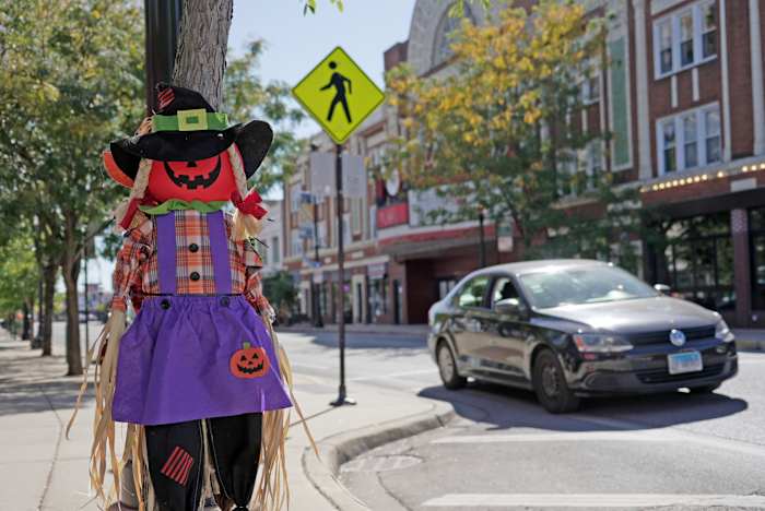 Een auto rijdt op 8 oktober 2024 over een zebrapad in de buurt van enkele Halloween-versieringen in Chicago. (AP Photo/Laura Bargfeld)