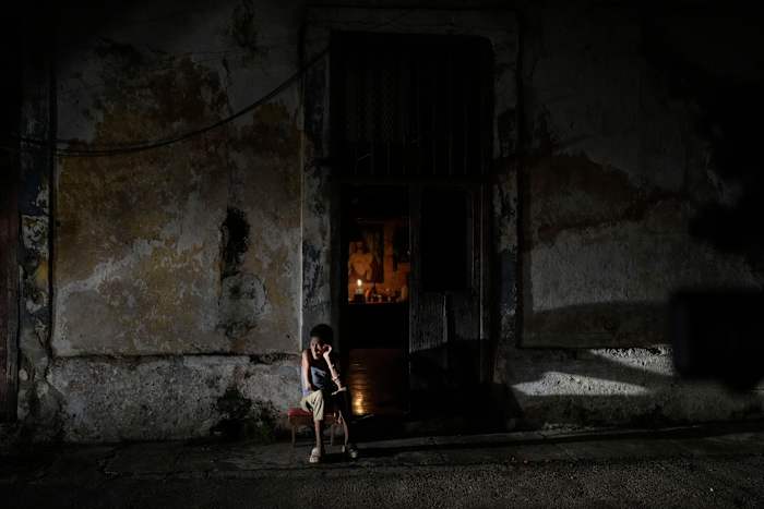 Een bewoner zit de tijd door te brengen tijdens een stroomstoring na het falen van een grote elektriciteitscentrale in Havana, Cuba, zaterdag 19 oktober 2024. (AP Photo/Ramon Espinosa)
