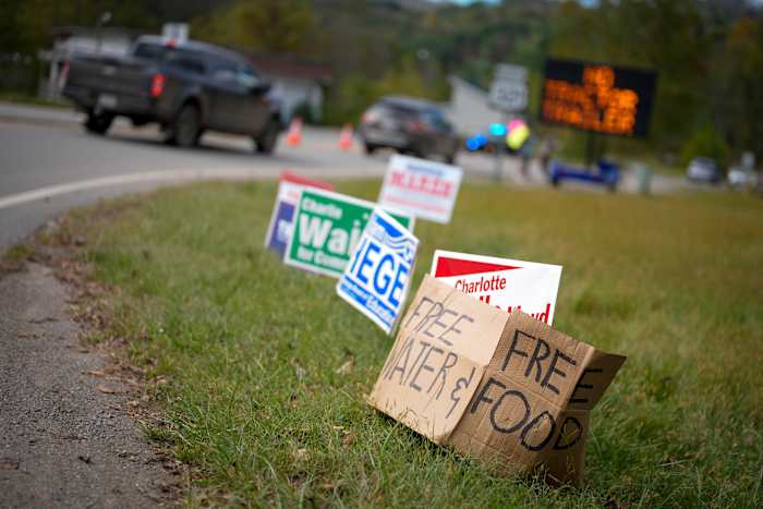 Een geïmproviseerd kartonnen bord leunt tegen campagneposters bij een opvangcentrum op donderdag 3 oktober 2024 in Vilas, NC, in de nasleep van de orkaan Helene. In de laatste weken van de presidentsverkiezingen hebben mensen in North Carolina en Georgia, invloedrijke swing states, te maken met meer directe zorgen: het herstel van de orkaan Helene. (AP-foto/Chris Carlson)