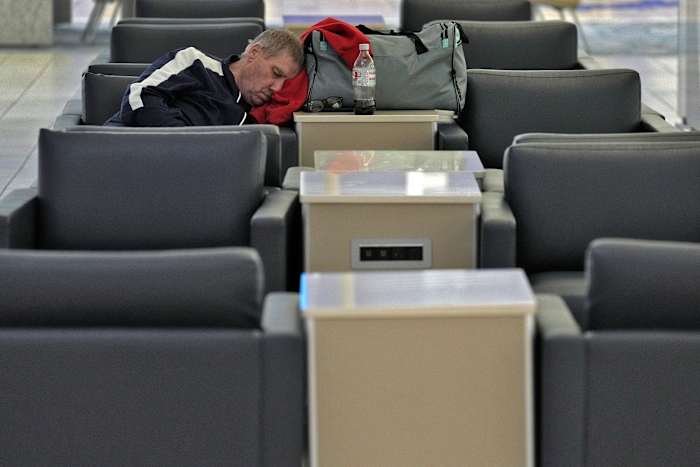 Een passagier slaapt op dinsdag 8 oktober 2024 op de Tampa International Airport in Tampa, Florida, nadat de meeste vluchten waren geannuleerd vanwege de mogelijke aankomst van orkaan Milton. (AP Foto/Chris O'Meara)