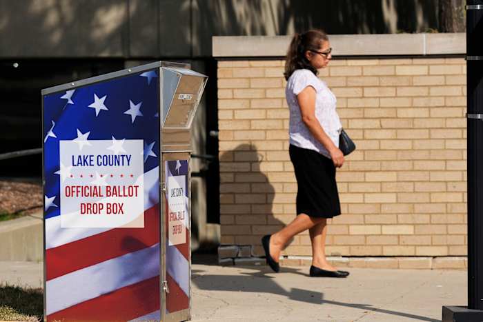 Een persoon loopt langs een stembus voor Lake County in het centrum van Waukegan in Waukegan, Illinois, maandag 16 september 2024. (AP Photo/Nam Y. Huh)