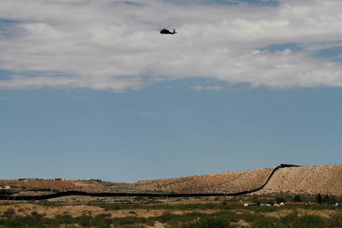 Een surveillancehelikopter volgt een lijn in de lucht boven de zuidwestelijke grens met Mexico in Sunland Park, NM, donderdag 22 augustus 2024. (AP Photo/Morgan Lee, File)
