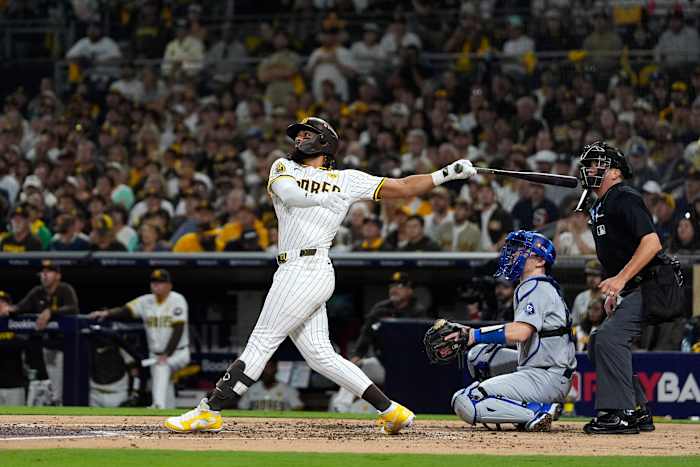 Fernando Tatis Jr. van San Diego Padres, links, volgt zijn homerun van twee runs terwijl Los Angeles Dodgers-catcher Will Smith, midden en thuisplaatscheidsrechter Cory Blaser toekijken tijdens de tweede inning in Game 3 van een honkbal NL Division Series , dinsdag 8 oktober 2024, in San Diego. (AP-foto/Gregory Bull)