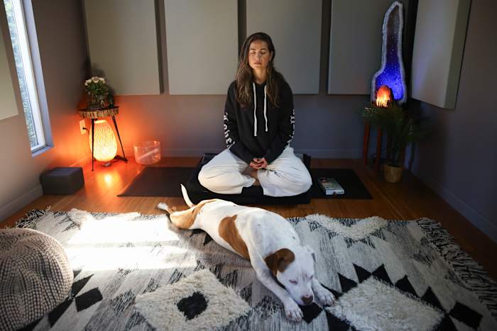 Headspace-meditatieleraar Rosie Acosta mediteert in haar studio met haar hond op maandag 30 september 2024 in Woodland Hills, Californië (AP Photo/Jessie Alcheh)