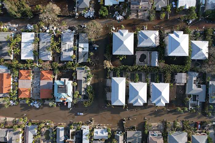 Het water van de overstroming trekt zich terug na de orkaan Milton, in straten waar stapels puin van de overstroming van de orkaan Helene buiten veel huizen liggen, in Siesta Key, Florida, donderdag 10 oktober 2024. (AP Photo/Rebecca Blackwell)