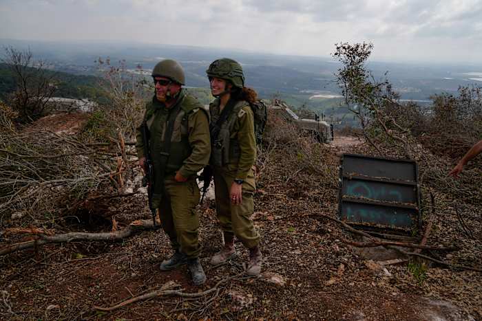 Israëlische soldaten tonen wat zij zeggen een ingang is van een Hezbollah-tunnel die is gevonden tijdens hun grondoperatie in Zuid-Libanon, vlakbij de grens met Israël, zondag 13 oktober 2024. (AP Photo/Sam McNeil)