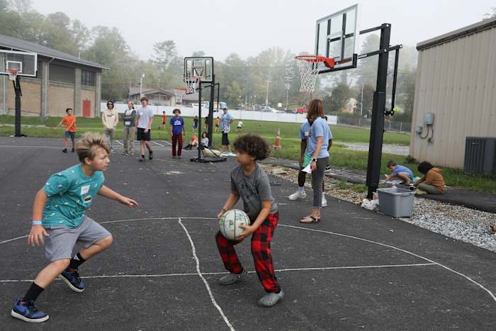 Jongens spelen basketbal op het Project:Camp pop-up dagkamp voor gezinnen die getroffen zijn door de orkaan Helene in Brevard, NC, maandag 7 oktober 2024. (AP Photo/Gabriela Aoun Angueira)