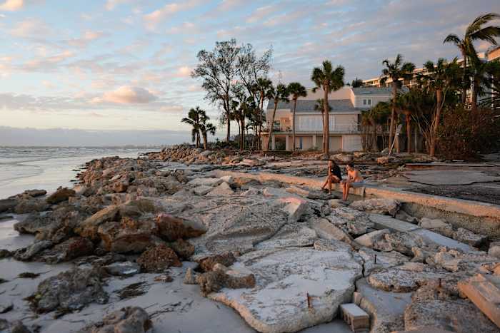Jongeren uit Sarasota, Florida, bezoeken een bekend strand op Siesta Key, Florida, dat volgens hen al was gedecimeerd door de orkaan Helene, en verloor nog meer zandbedekking tijdens de orkaan Milton, donderdag 10 oktober 2024. (AP Foto/Rebecca Blackwell)