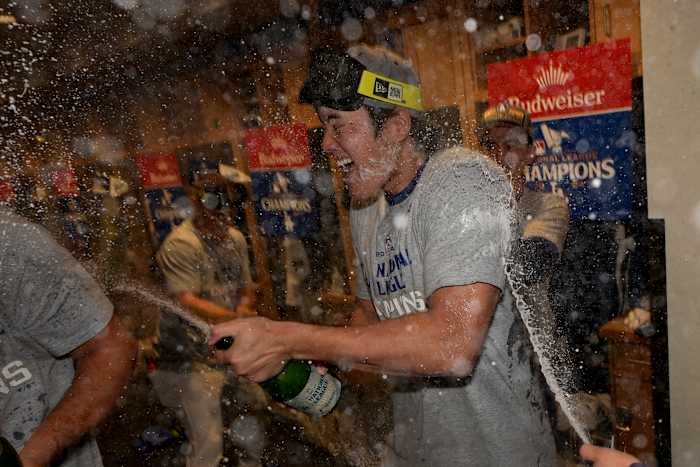 Los Angeles Dodgers Shohei Ohtani viert feest in de kleedkamer na hun overwinning tegen de New York Mets in Game 6 van een honkbal NL Championship Series, zondag 20 oktober 2024, in Los Angeles. De Dodgers zullen het opnemen tegen de New York Yankees in de wereld (AP Photo/Ashley Landis)