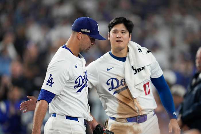 Los Angeles Dodgers-werper Jack Flaherty, links, wordt begroet door Shohei Ohtani als hij terugkeert naar de dug-out tijdens de zevende inning in Game 1 van een honkbal NL Championship Series tegen de New York Mets, zondag 13 oktober 2024, in Los Angeles . (AP-foto/Ashley Landis)