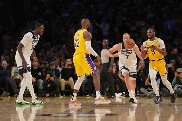 Los Angeles Lakers-aanvaller LeBron James (23) passeert om Bronny James (9) te bewaken tijdens de eerste helft van een NBA-basketbalwedstrijd tegen de Minnesota Timberwolves, dinsdag 22 oktober 2024, in Los Angeles. (AP-foto/Eric Thayer)