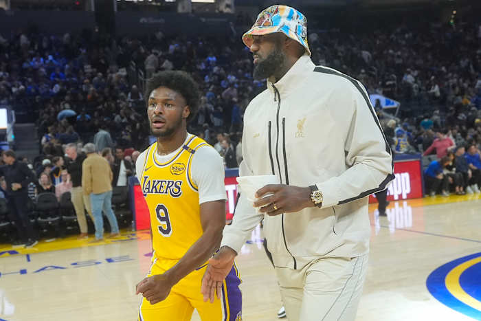 Los Angeles Lakers-bewaker Bronny James (9) loopt van de vloer met aanvaller LeBron James tijdens de rust van een basketbalwedstrijd van het NBA-voorseizoen tegen de Golden State Warriors in San Francisco, vrijdag 18 oktober 2024. (AP Photo/Jeff Chiu)