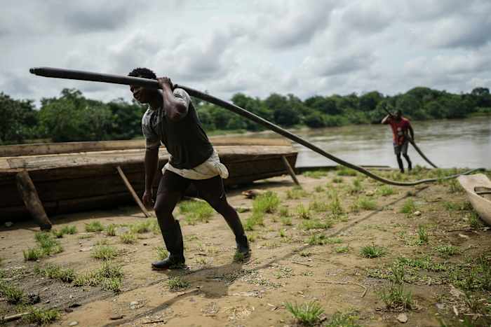 Mannen dragen slangen om benzine te vervoeren in El Arenal, Colombia, donderdag 26 september 2024. (AP Photo/Ivan Valencia)