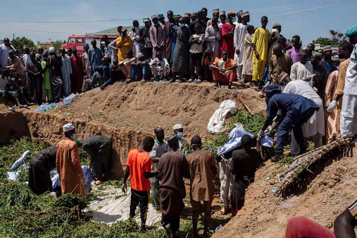 Mensen bereiden lichamen voor op de begrafenis na een tankerexplosie in de stad Majiya, Nigeria, woensdag 16 oktober 2024. (AP Photo/ Sani Maikatanga)