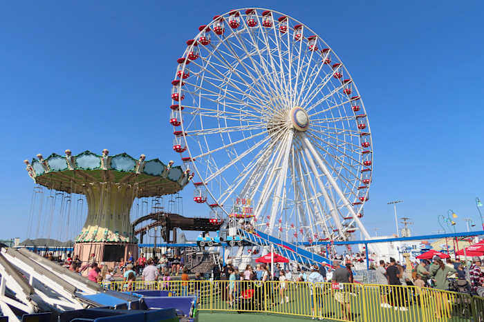 Mensen rijden in het reuzenrad en vliegen in een stoel in Gillian's Wonderland, het populaire pretpark aan de promenade in Ocean City, NJ, tijdens de laatste werkdag voordat het voorgoed wordt gesloten, zondag 13 oktober 2024. (AP Photo/ Wayne Parry)
