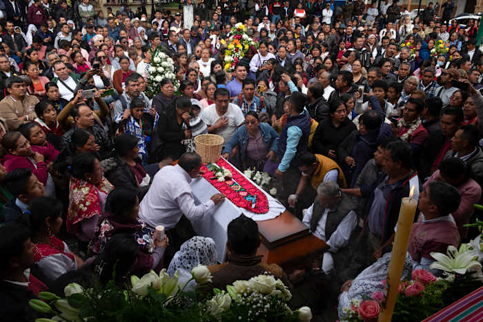 Mensen verzamelen zich rond de kist van de vermoorde katholieke priester en activist Marcelo Prez tijdens een mis op het belangrijkste plein in San Andrs Larrinzar, staat Chiapas, Mexico, maandag 21 oktober 2024. (AP Photo/Isabel Mateos)