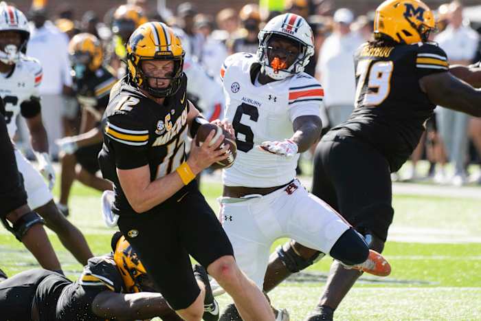 Missouri quarterback Brady Cook, links, draait weg van Auburn linebacker Austin Keys tijdens de tweede helft van een NCAA college football-wedstrijd op zaterdag 19 oktober 2024 in Columbia, Mo. Missouri won met 21-17. (AP-foto/LG Patterson)