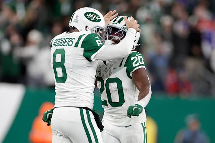New York Jets quarterback Aaron Rodgers (8) viert feest met running back Frank Gore Jr. (20) na het gooien van een touchdown pass naar wide receiver Allen Lazard tijdens de eerste helft van een NFL-voetbalwedstrijd tegen de Buffalo Bills in East Rutherford, NJ, maandag 14 oktober 2024. (AP Foto/Adam Hunger)