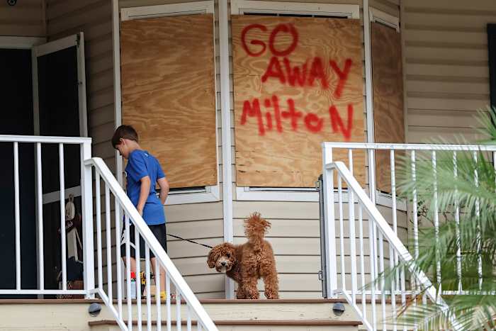 Noah Weibel en zijn hond Cookie beklimmen de trap naar hun huis terwijl hun gezin zich voorbereidt op de orkaan Milton op maandag 7 oktober 2024 in Port Richey, Florida. (AP Photo/Mike Carlson)