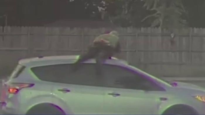 Op dashcambeelden is te zien hoe de agent het dak van de auto vasthield terwijl de verdachte verder wegreed