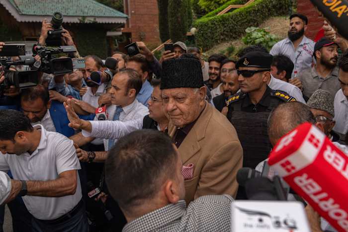 Partijleider Farooq Abdullah van de Nationale Conferentie, midden, draagt ​​een zwarte pet, wordt omringd door journalisten terwijl de partij vroege voorsprong viert bij de verkiezingen voor een lokale regering in het door India gecontroleerde Kasjmir, Srinagar, dinsdag 8 oktober 2024. (AP Photo/Dar Yasin )