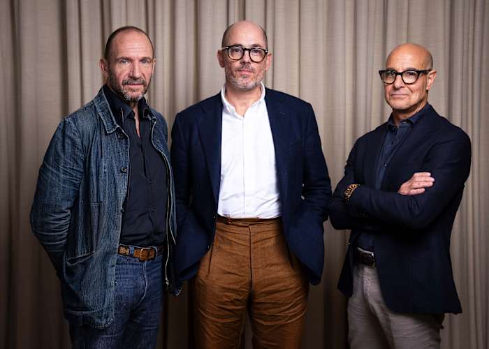 Ralph Fiennes, van links naar rechts, regisseur Edward Berger en Stanley Tucci poseren voor portretfoto's voor de film "Conclaaf'"op donderdag 10 oktober 2024 in Londen. (Foto door Scott A Garfitt/Invision/AP)