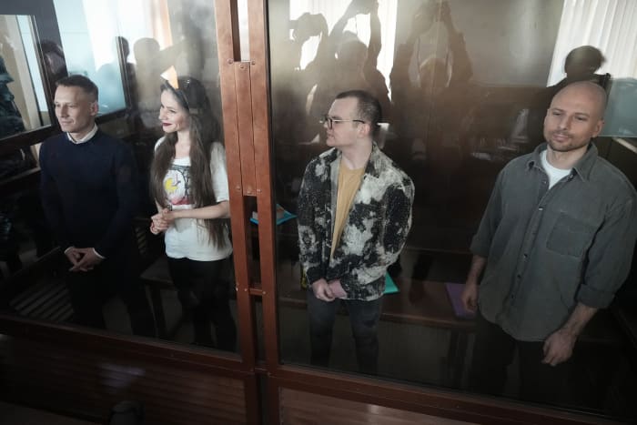 Russische journalisten, van links naar rechts, Konstantin Gabov, Antonina Favorskaya, Artyom Kriger en Sergey Karelin, beschuldigd van het werken voor een groep opgericht door de overleden Russische oppositiepoliticus Alexei Navalny, staan ​​in de kooi van een verdachte van de Nagatinsky District Court in Moskou, Rusland, op Woensdag 2 oktober 2024. (AP Foto)